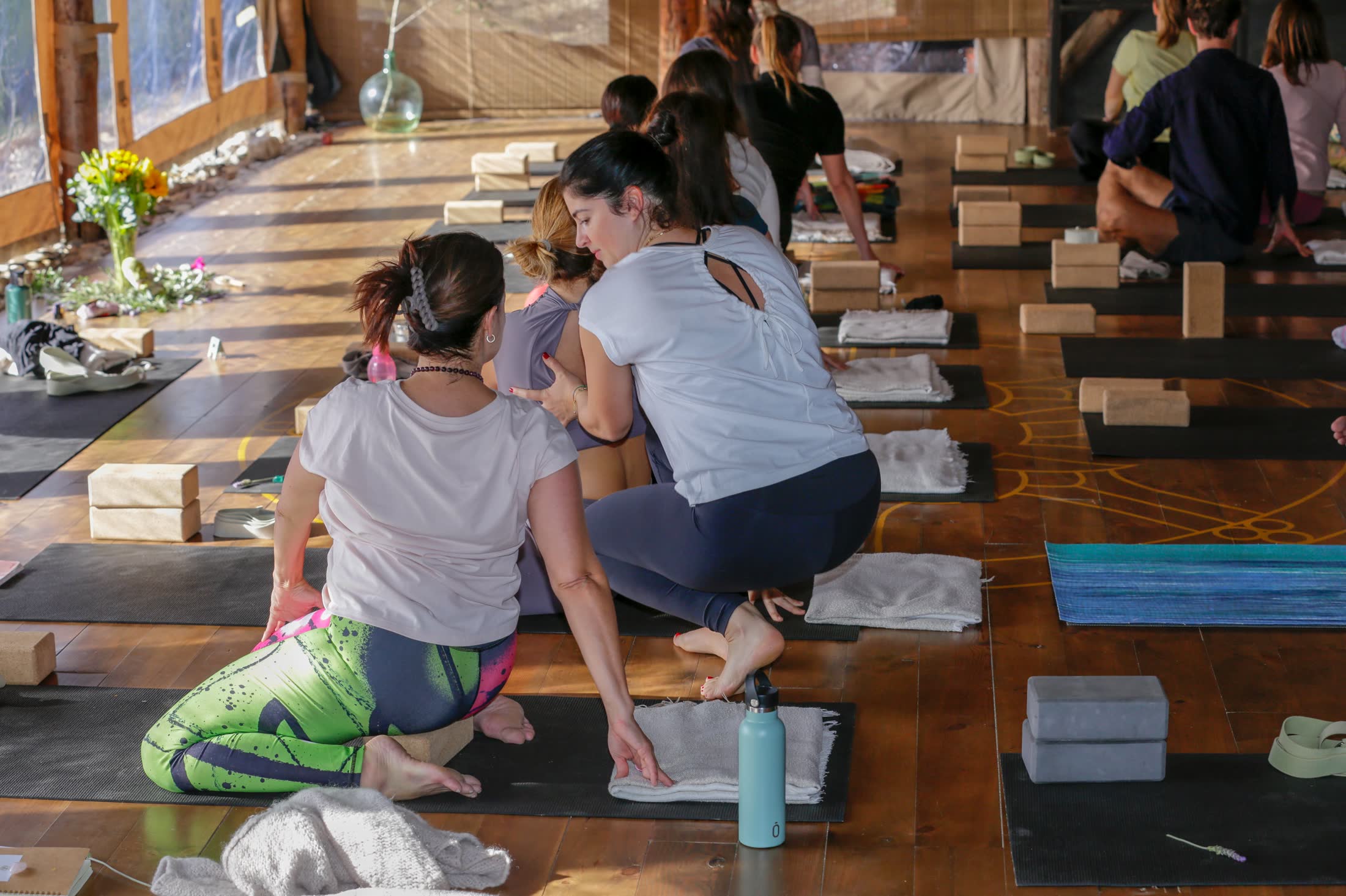 Nadine begleitet Teilnehmende in einem persönlichen Yoga-Kurs